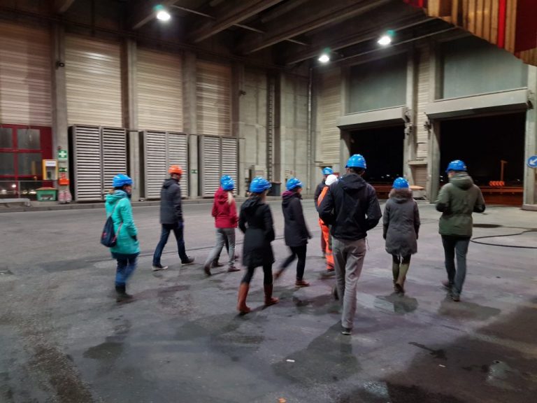 Gruppe mit blauen Helmen geht in Anlage rein