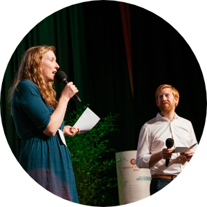Nora und Tim von Cradle to Cradle NGO auf Bühne, sprechend mit Mikrofon