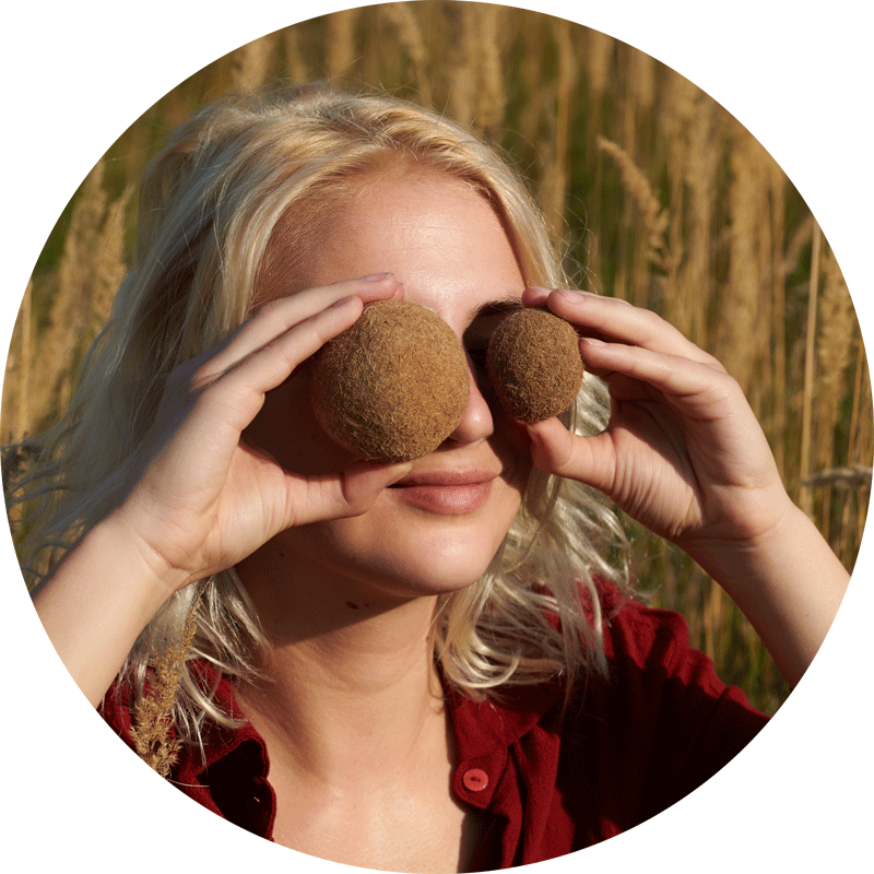 young white woman holding two brown balls in front of her eyes image on website Cradle to Cradle C2C