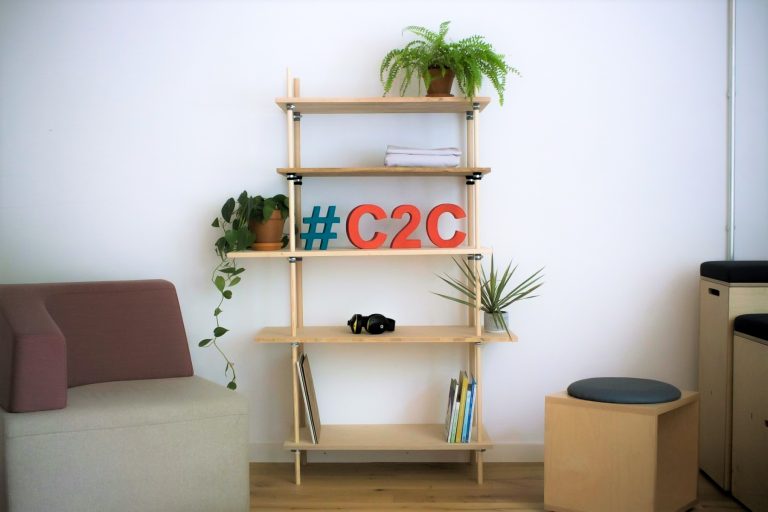 Ein Regal aus Holz steht vor einer Wand. Auf dem Regal steht "#C2C"