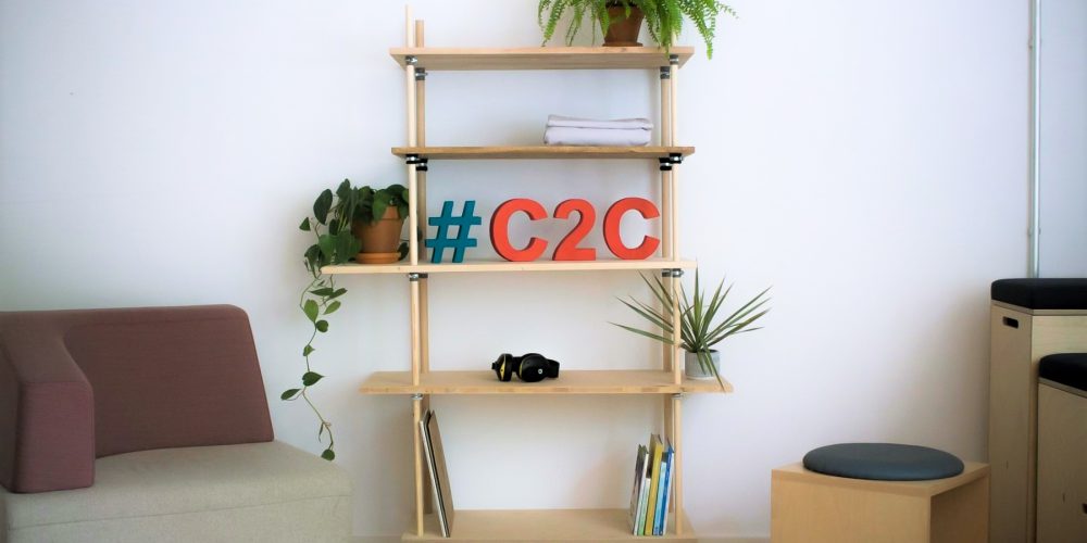 Ein Regal aus Holz steht vor einer Wand. Auf dem Regal steht "#C2C"