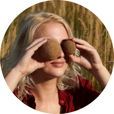 young white woman holding two brown balls in front of her eyes image on website Cradle to Cradle C2C